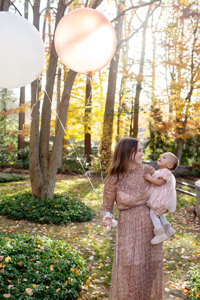 Family session of little girl and her mother holding balloons