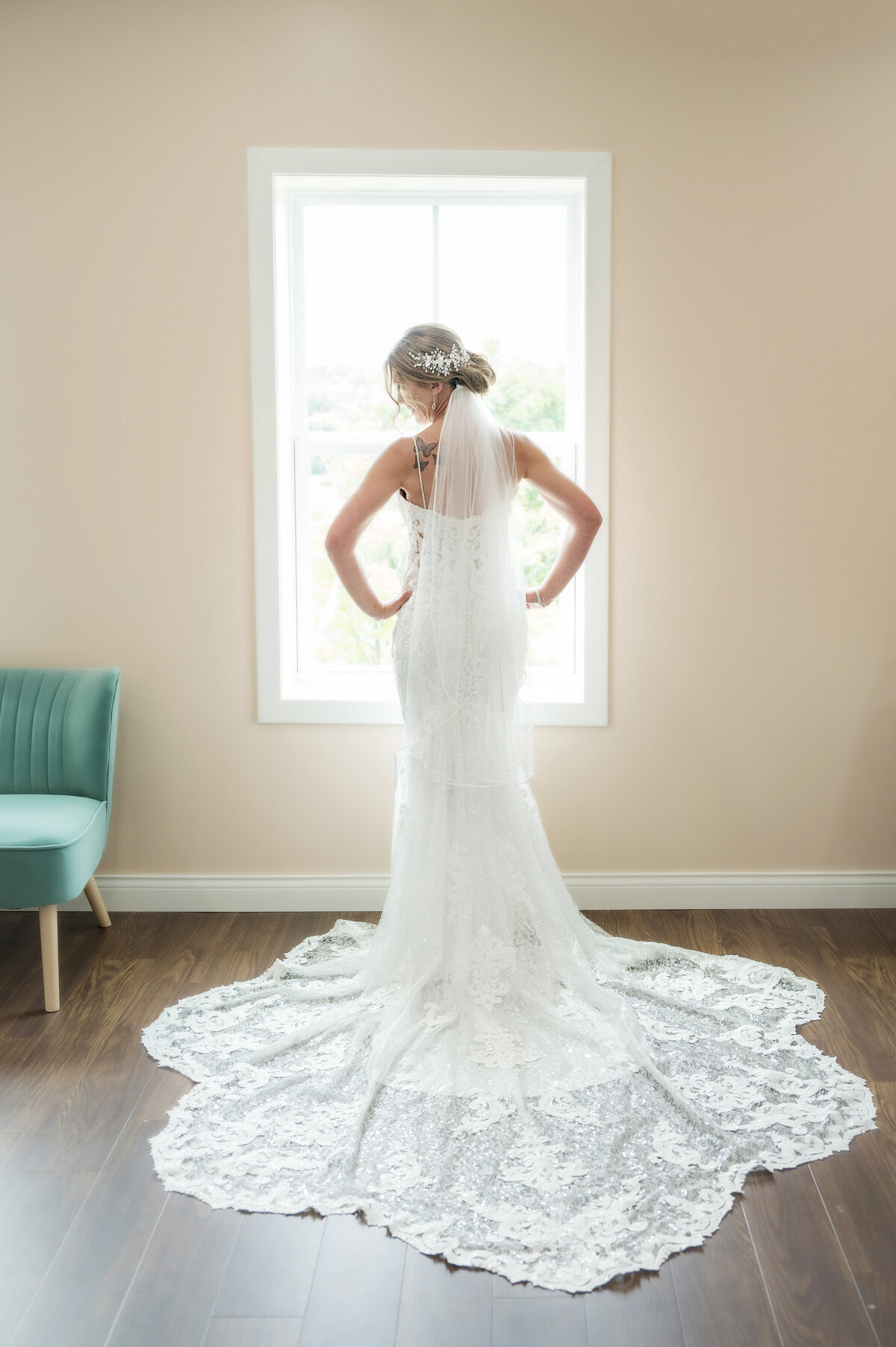 Bride with wedding dress in front of glowing window light.