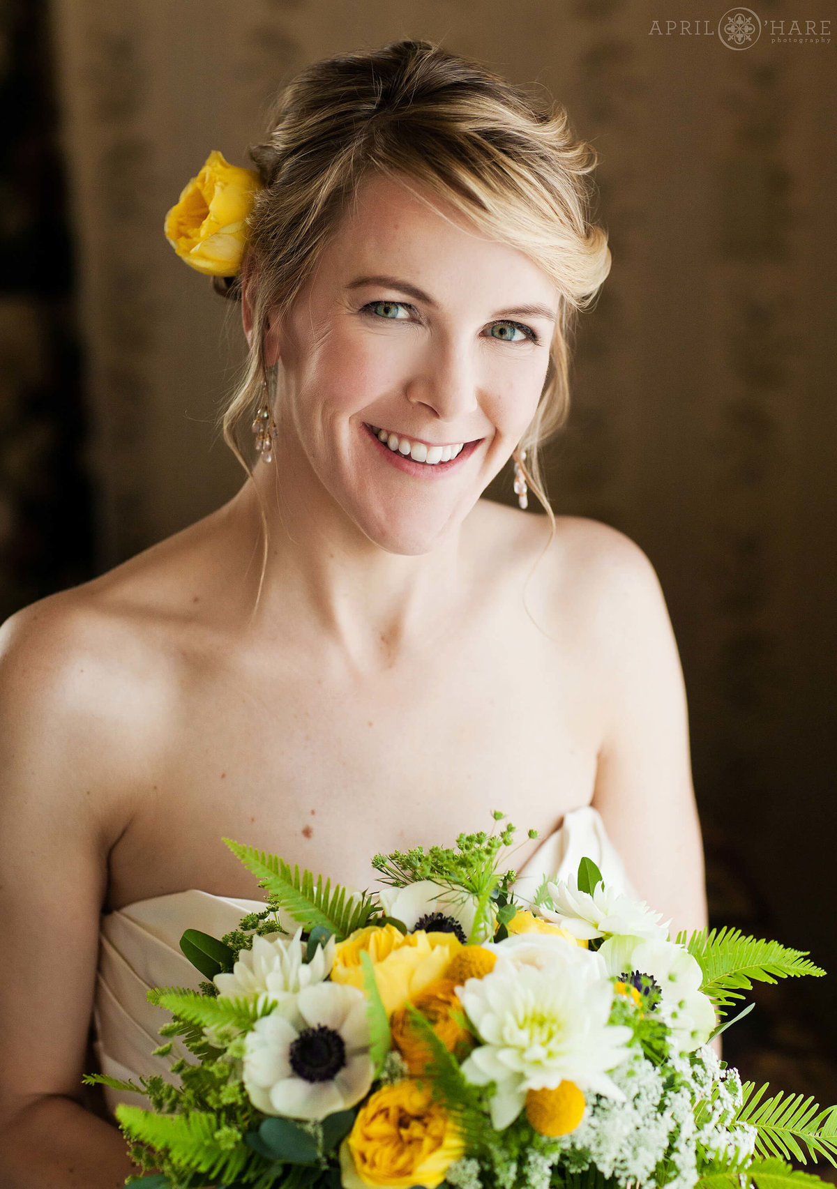 Natural light bridal portrait of bride with yellow rose in her hair at Hotel Boulderado