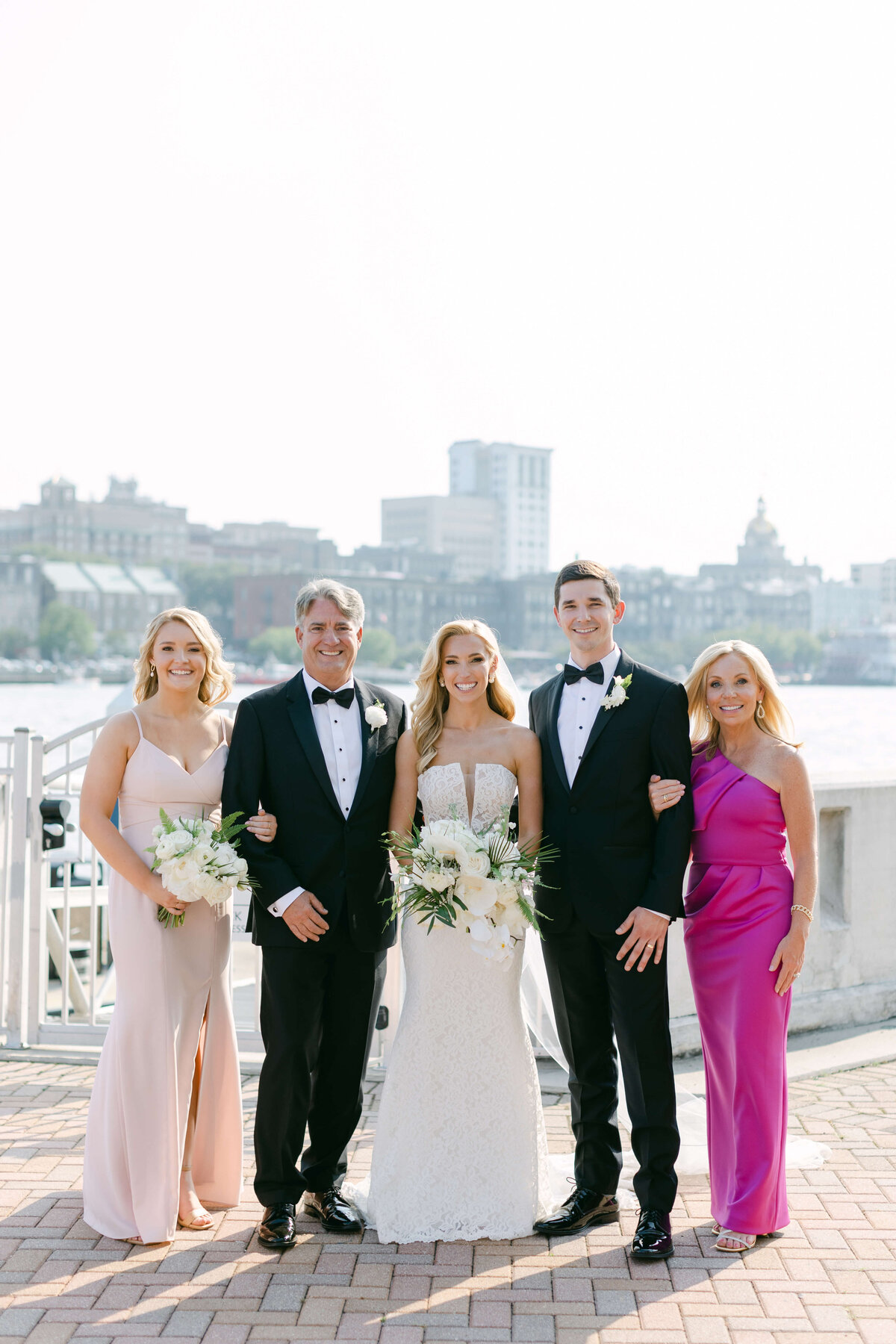 A bride and groom stand with their family.