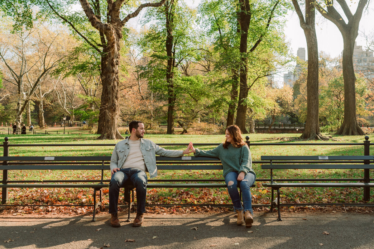 man and woman sitting on opposite sides of park bench while looking at each other