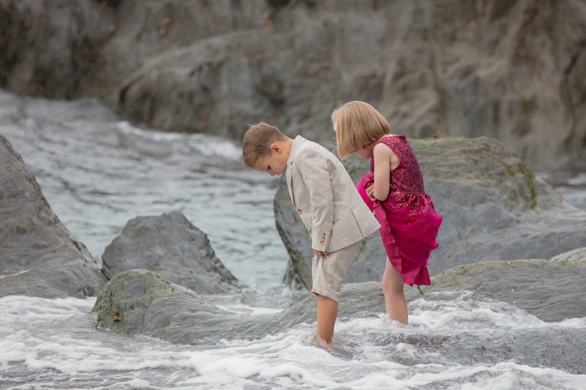 Flower girl and page boy barefoot in the sea at Tunnels Beaches Devon