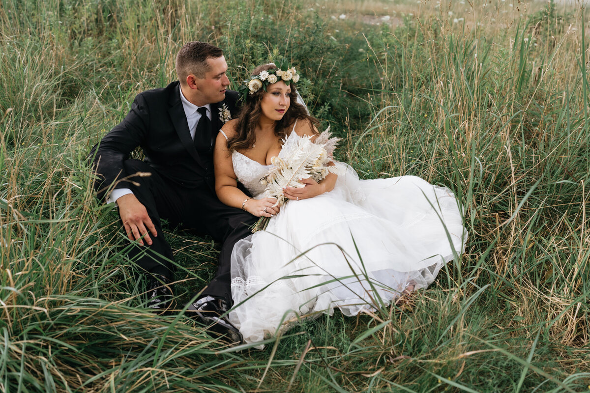 Bride and groom laying in grass