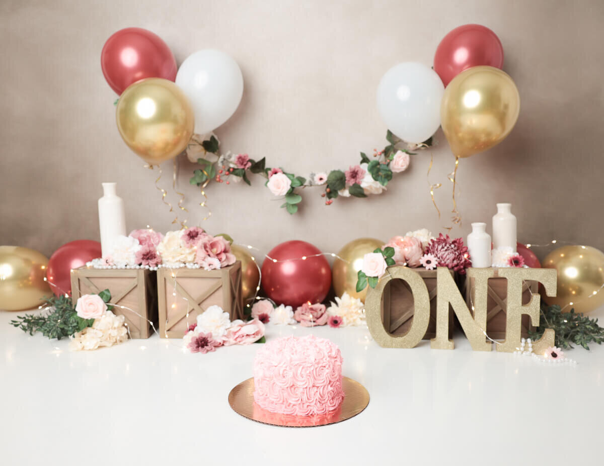 Beautifully styled boho cake smash scene with a decorated cake and playful props in Rochester, NY.
