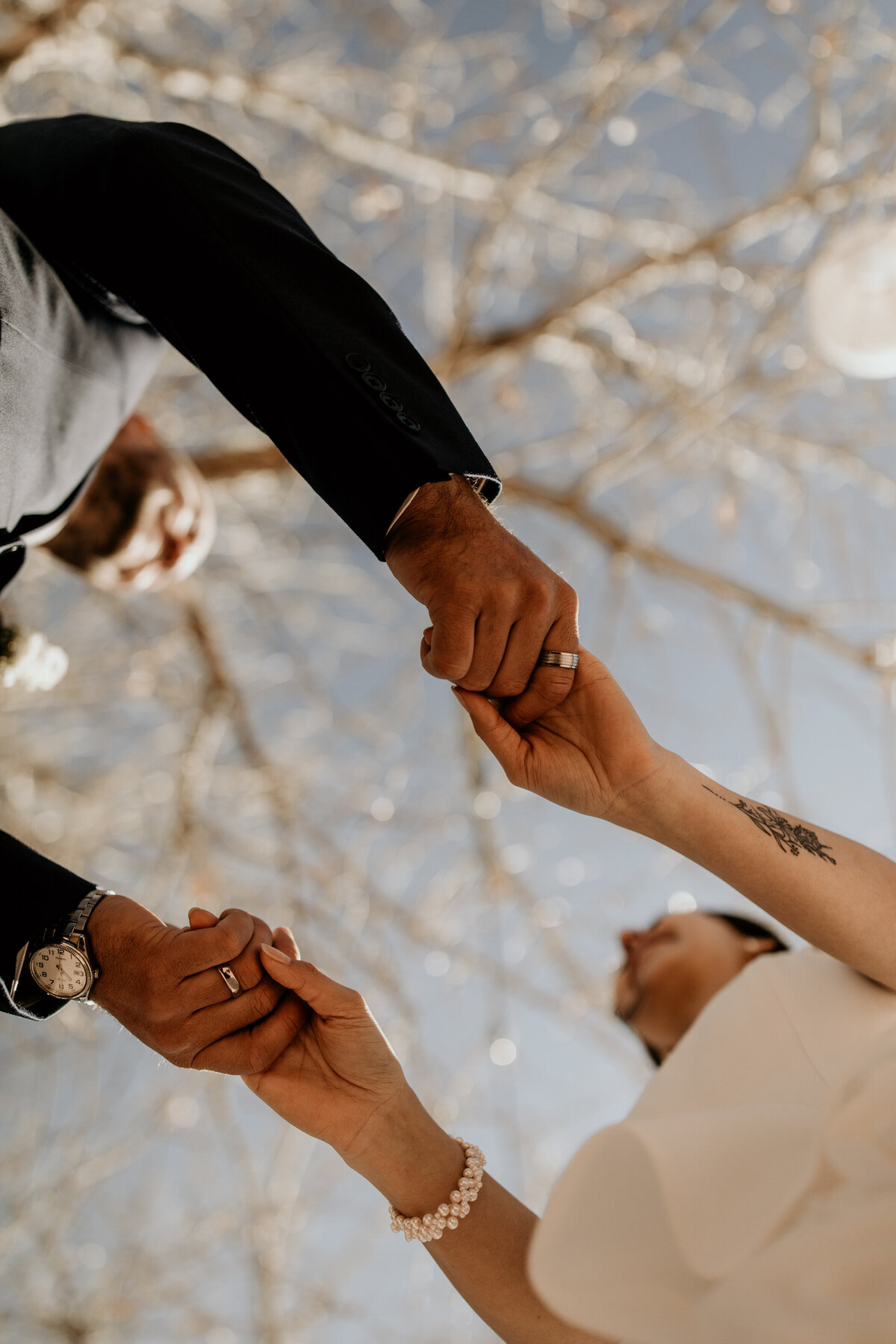 Bride and grooms hands holding from below