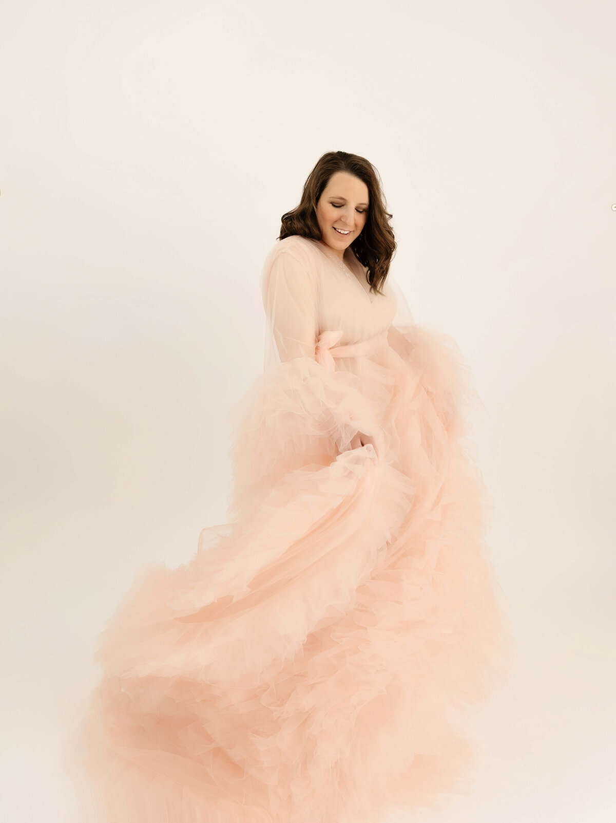 Maternity photo of pregnant girl in a pink robe swirling in an Erie Pa studio