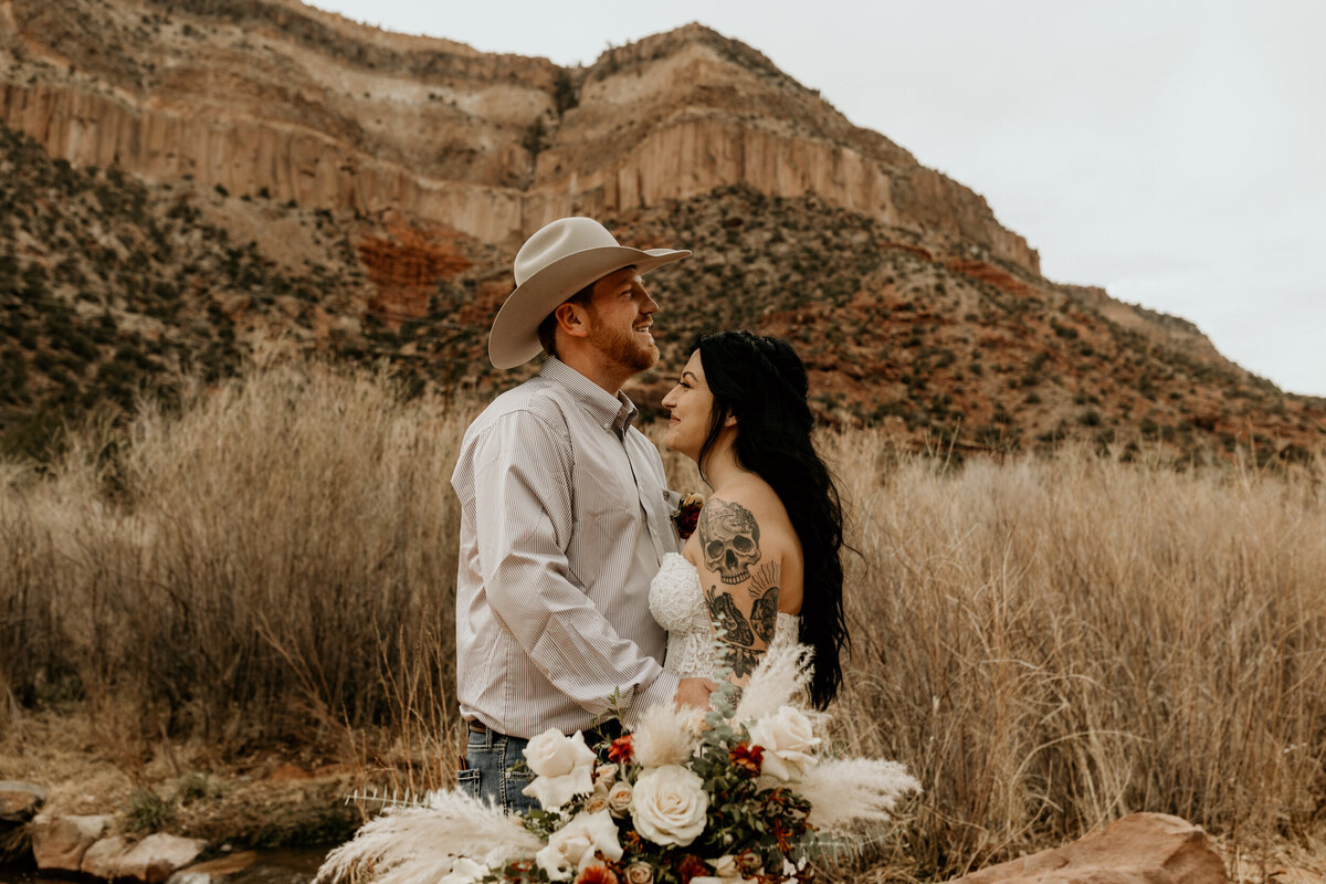 bride and groom in front of red rock mountains in New Mexico