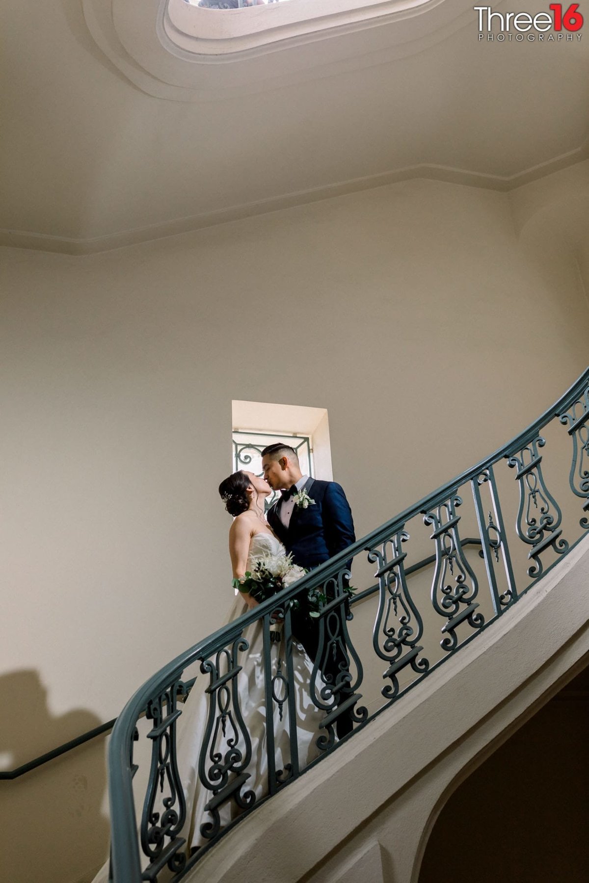 Bride and Groom share a tender kiss on the spiral staircase at the NOOR