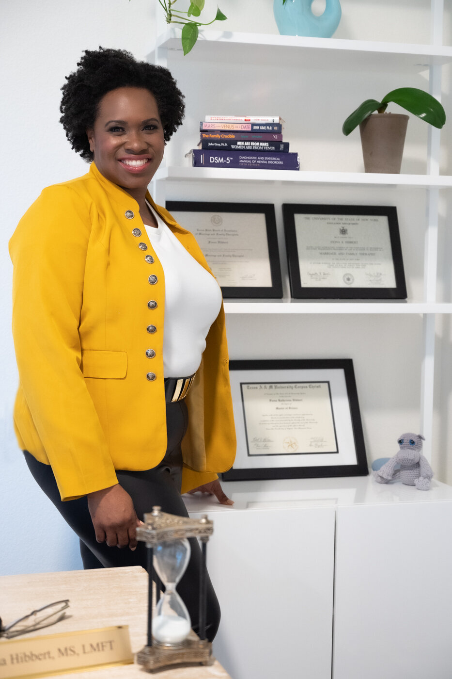 a woman posing next to her certificates