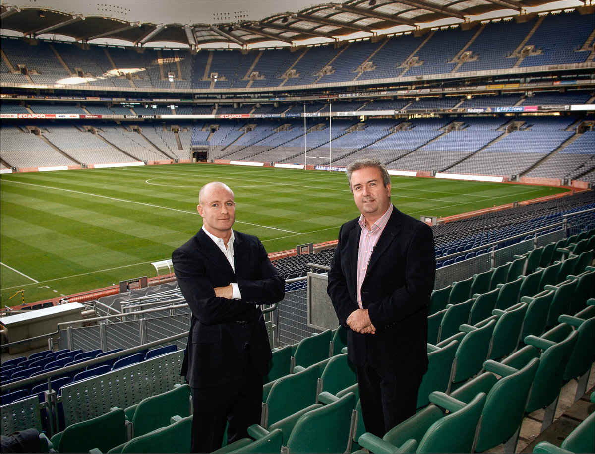 Two businessmen standing in an empty football stadium