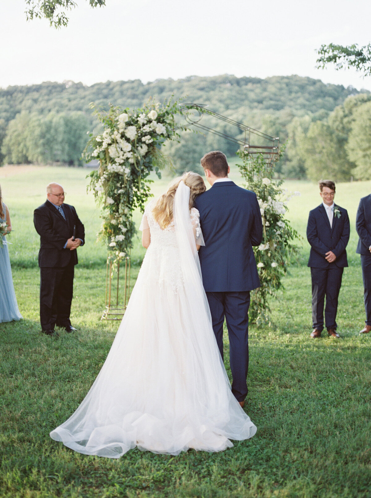 A bride lays her head over on her groom's shoulder during a ceremony at Sweet Seasons Farm by Chattanooga wedding photographer, Kelsey Dawn Photography