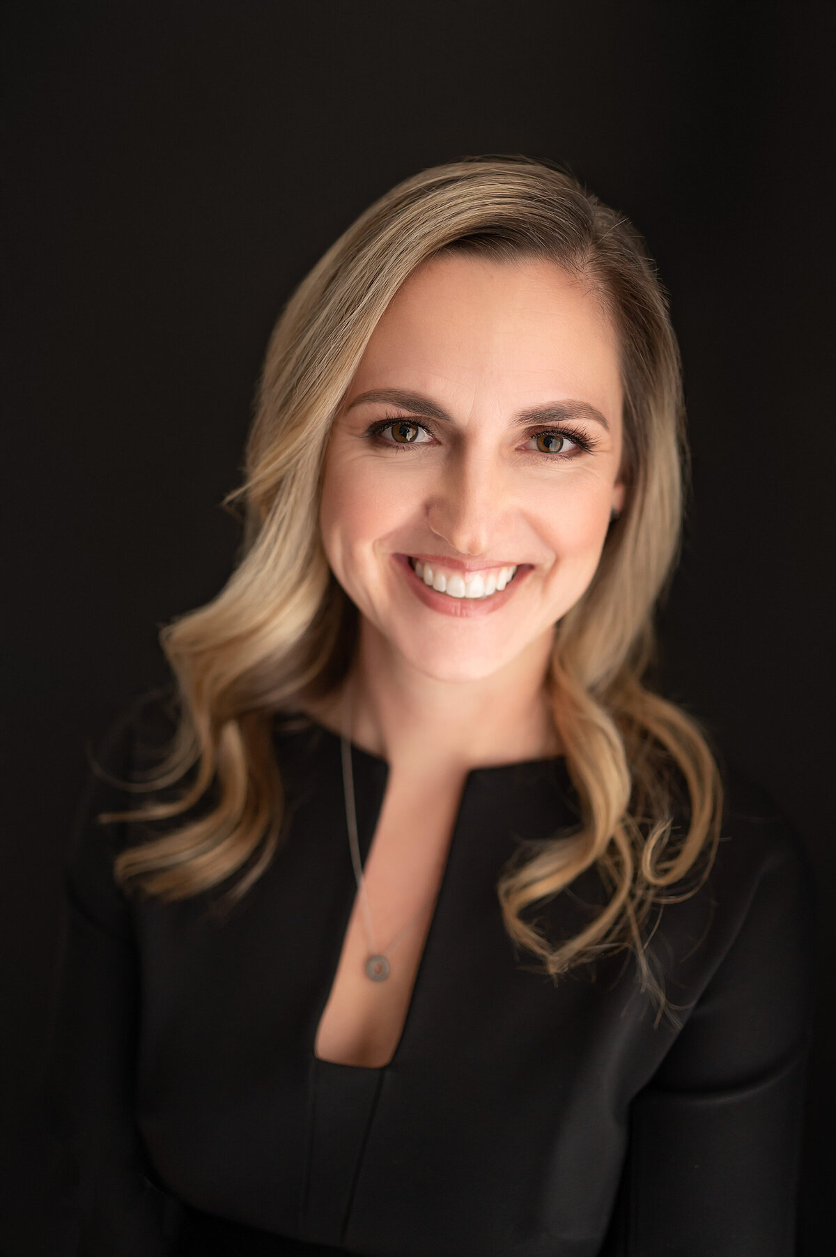 A Milwaukee banker sports an all black wardrobe in our Waukesha portrait studio as she gets a new set of professional headshots taken.