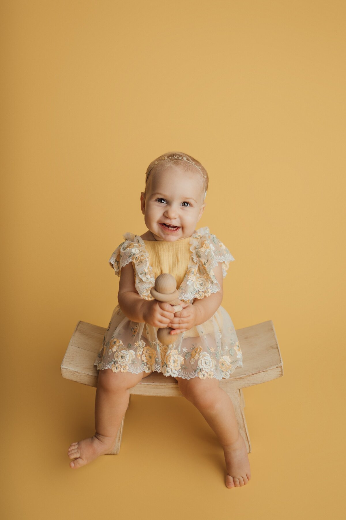 girl sitting on stool for first birthday portraits in tampa