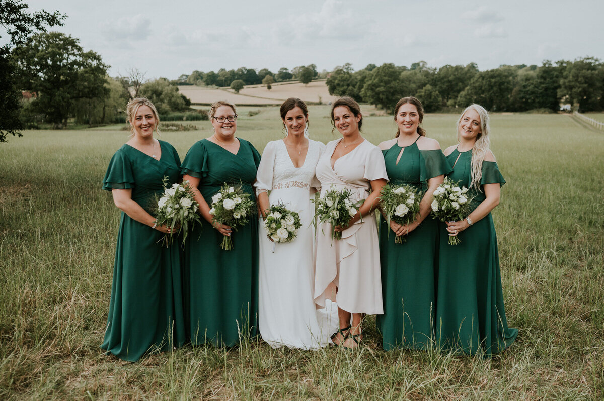 bride with bridemaids posing for photo in Kent countryside