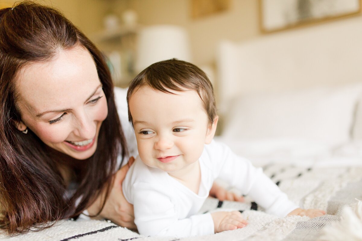 A mom laughing with and snuggling baby son at in-home photo session in Lexington KY.