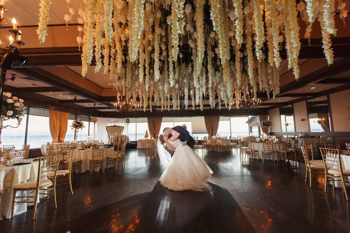 Groom Dips Bride for a Kiss in their Empty Reception Room at their Rusty Pelican Wedding in Tampa Bay Florida