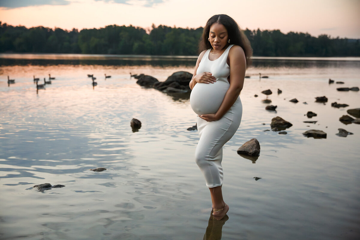 A beautiful sunset maternity session at Loch Raven Reservoir with maternity mother standing in the lake.