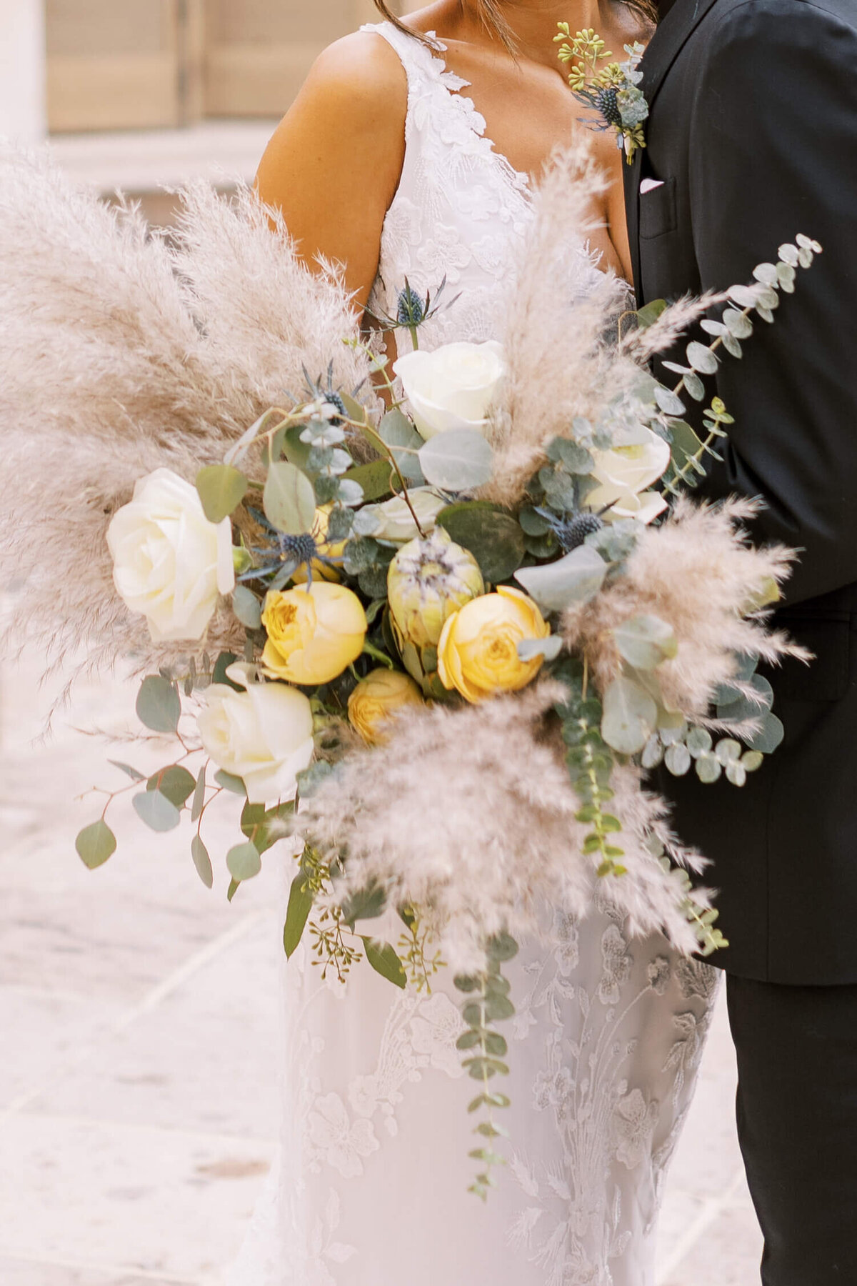gorgeous and huge wedding bouquet with ranunculus, roses, pampas grass, and eucalyptus for this timeless wedding in southern california