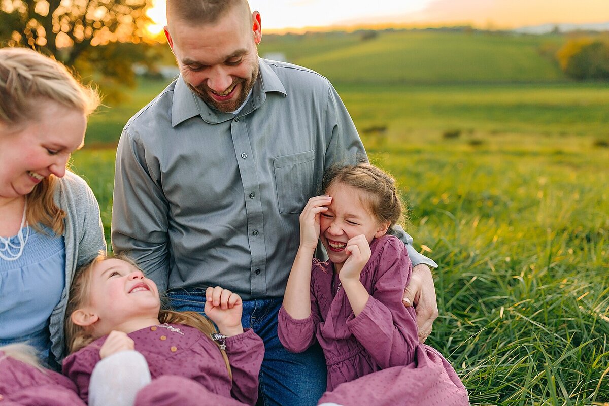 Family laughing and tickling in a field in Harrisonburg, VA