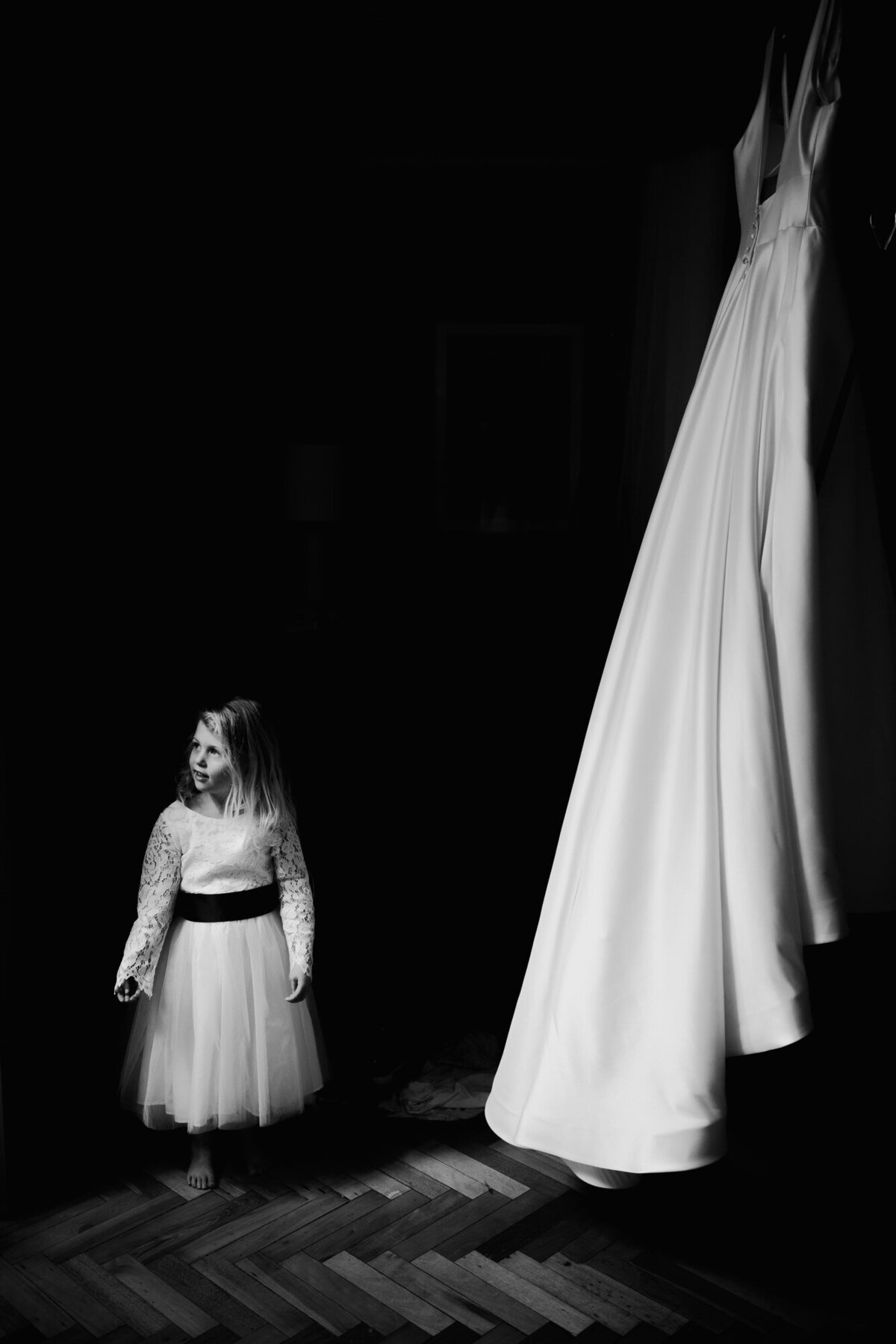 Black and white photo of young girl and brides wedding dress