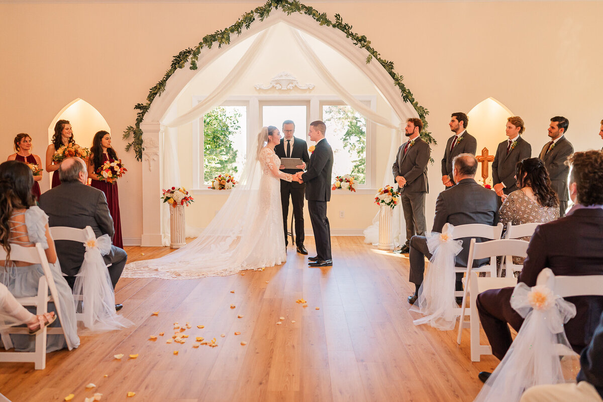 A bride and groom saying I do in their wedding chapel during the fall in Wilmington by Wilmington wedding photographer, JoLynn Photography