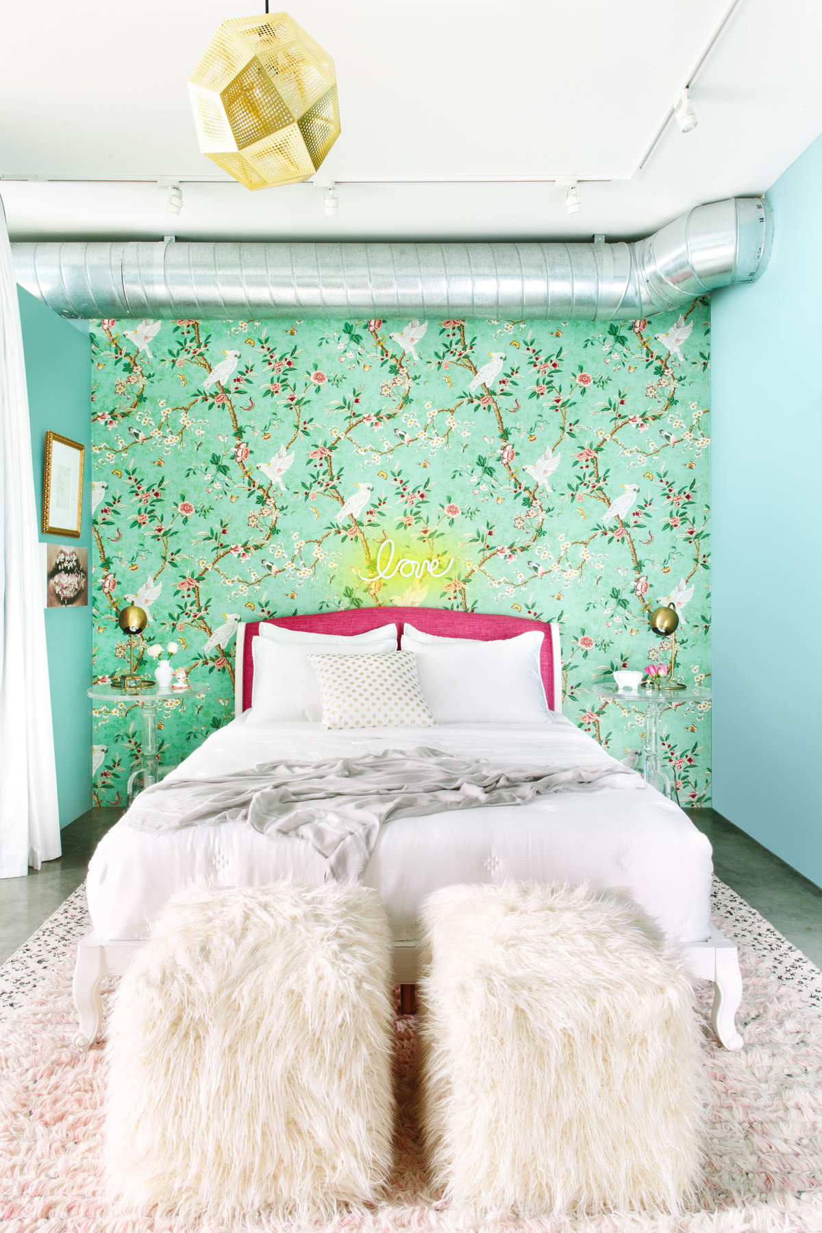 Bedroom with floral wallpaper, pink headboard, and Lucite acrylic nightstand