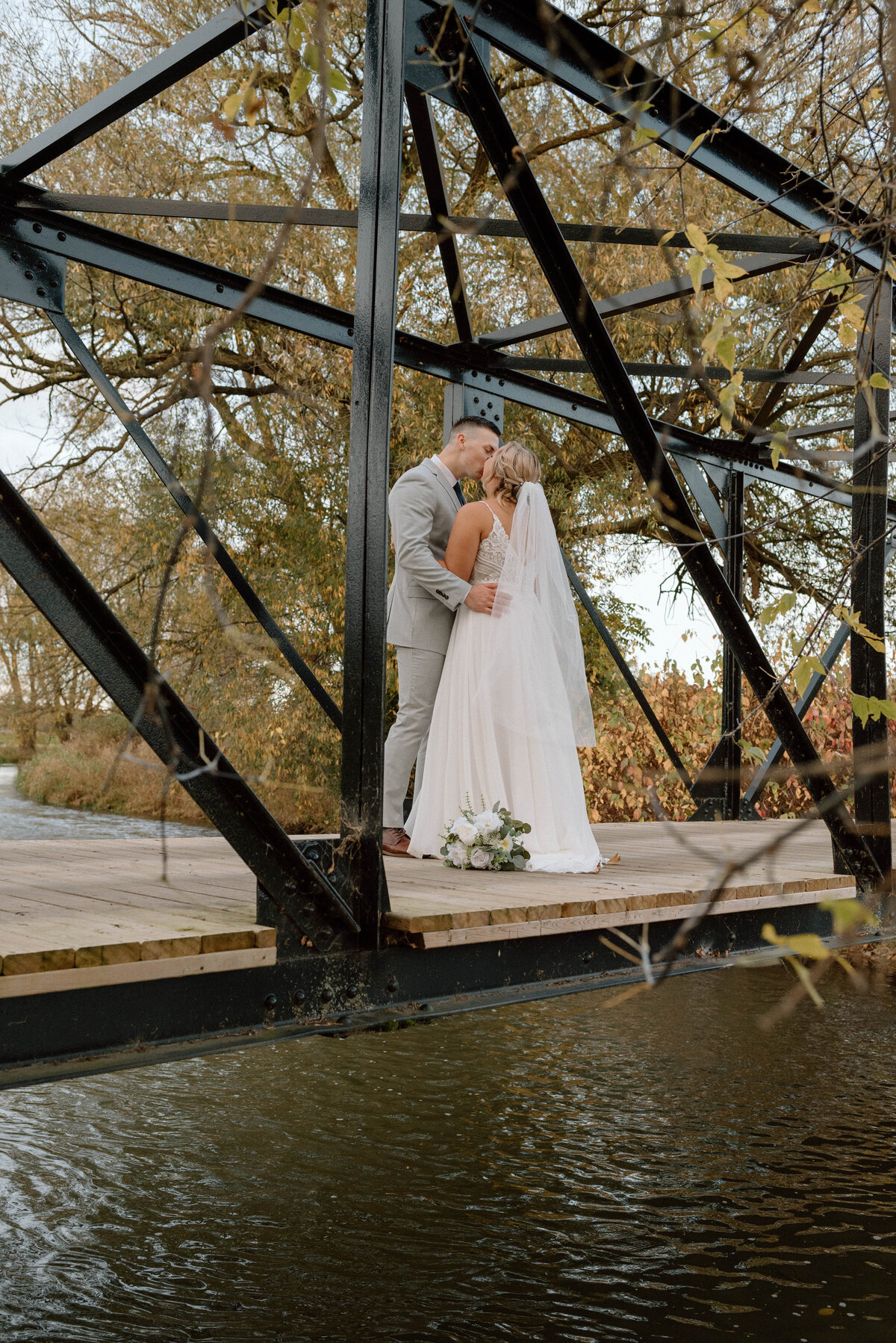bride and groom kiss on the bridge