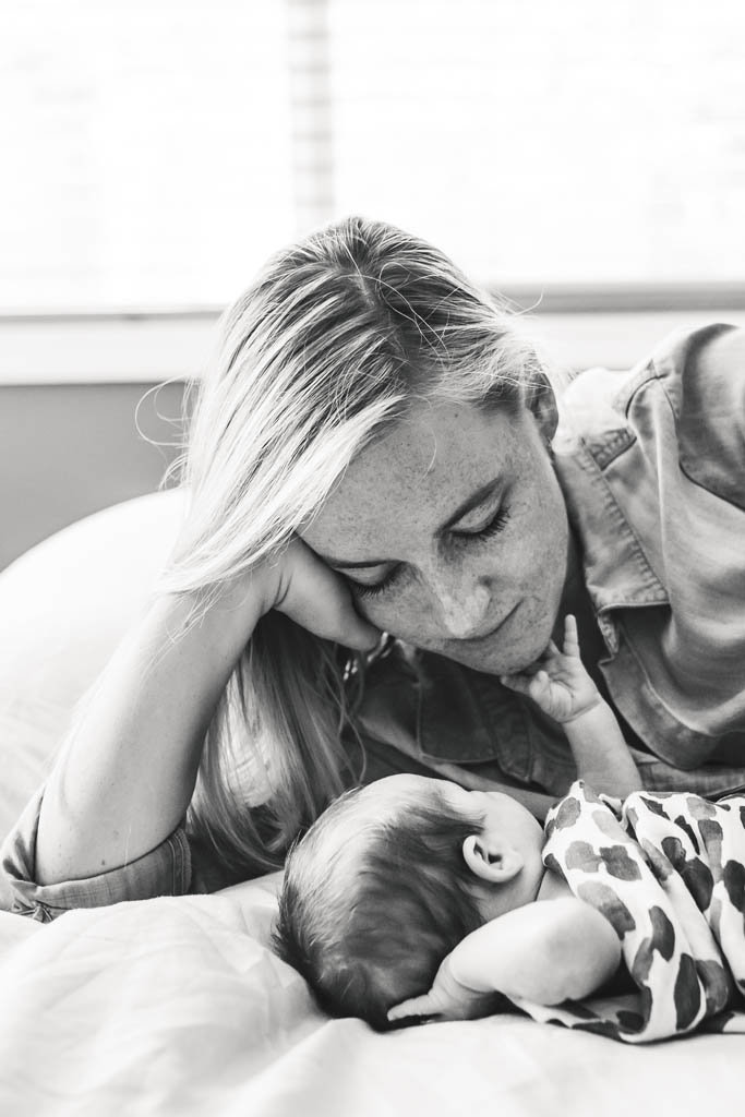 Tender connection of newborn baby reaches up and touches mother's chin