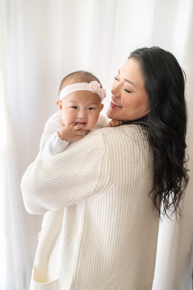 Family session of little girl wearing a bow and her mother