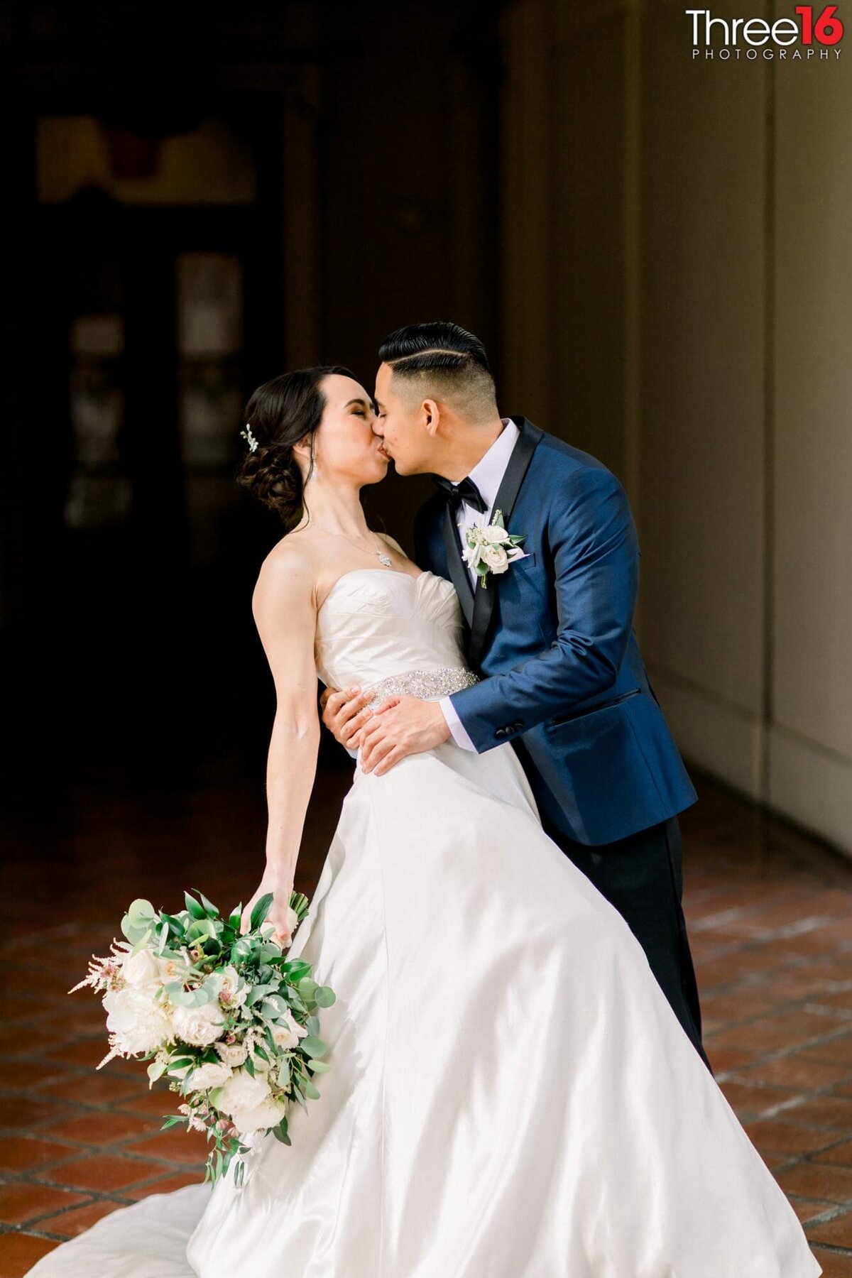 Groom dips his Bride and kisses her