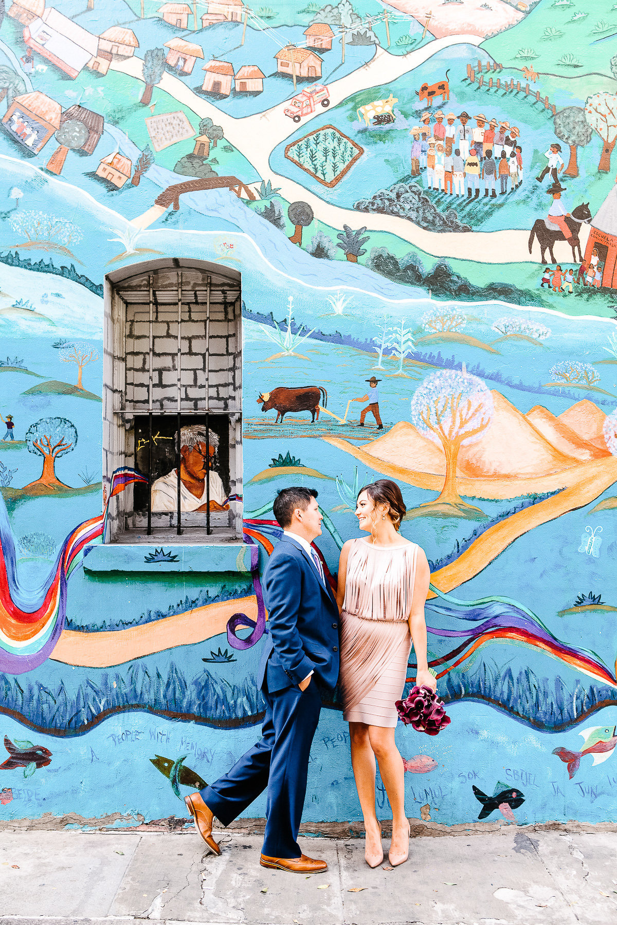 An elopement in San Francisco with a mural as a background.