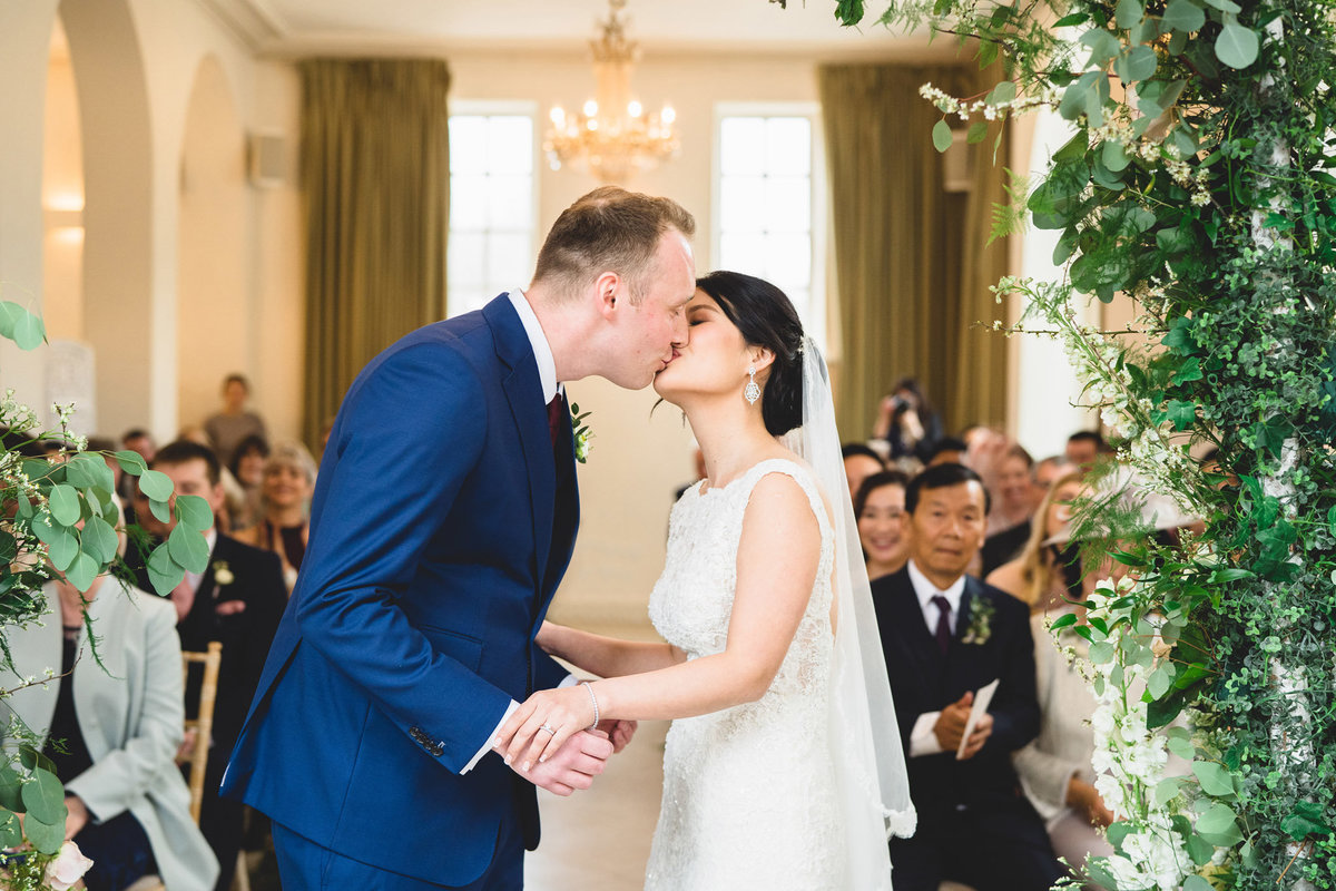 A bride and groom give each other a kiss during the wedding ceremony in the main house