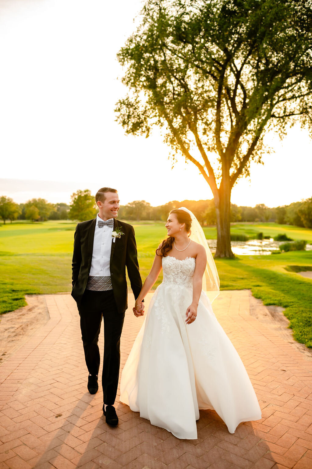 Couple holds hands at sunset on the golf course at the Skokie Country Club