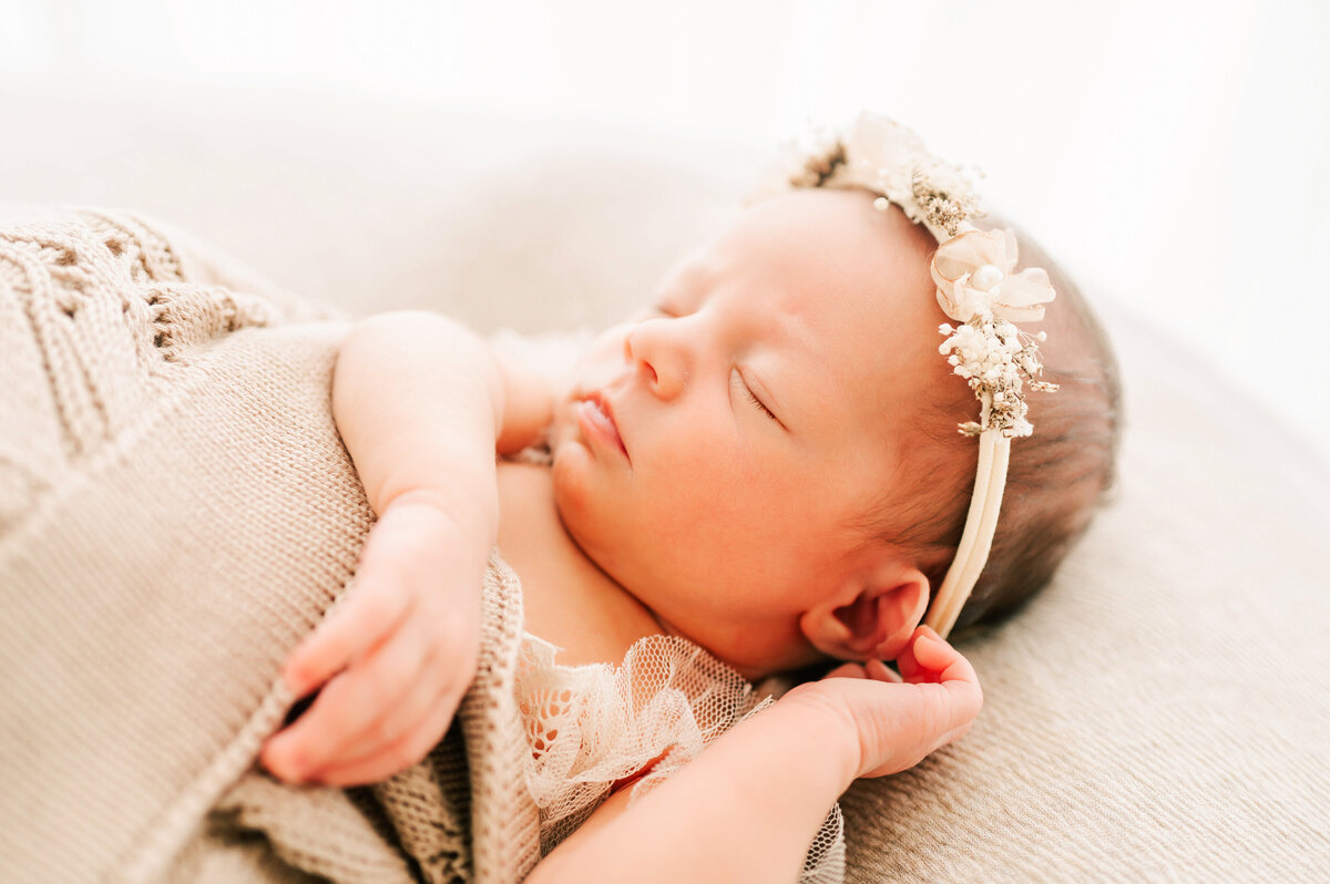 Springfield MO newborn photographer Jessica Kennedy of The XO Photography captures sleeping baby girl holding her ear  in floral crown