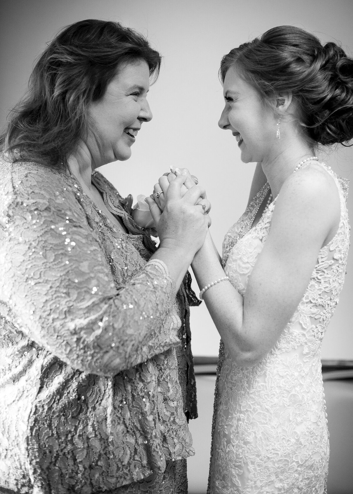 bride and her mom holding hands excitedly before wedding