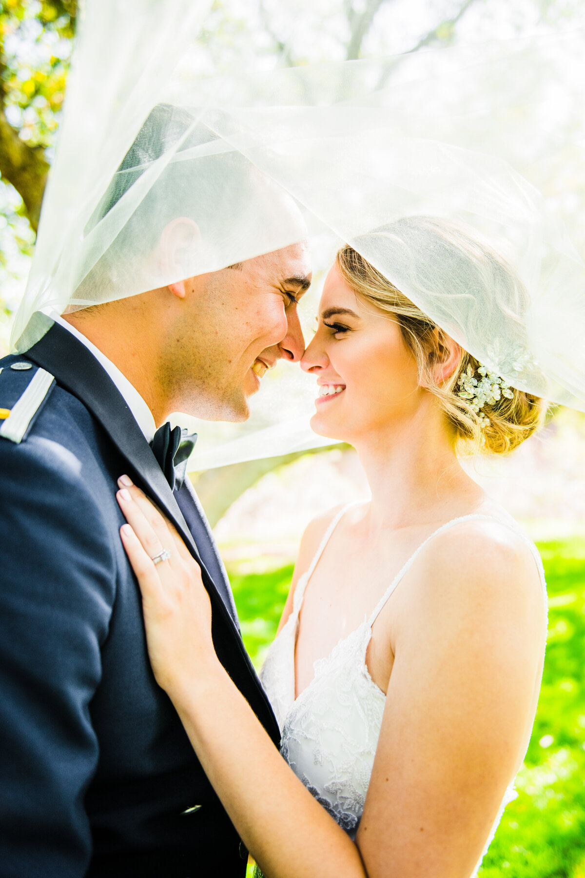 Bride and groom smiling under veil wedding Prescott wedding Air Force