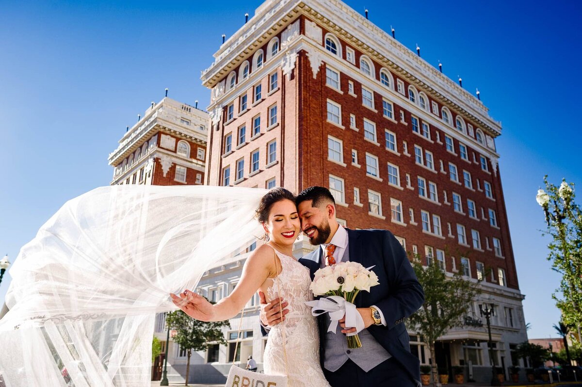 bride and groom behind paso del norte hotel In el paso texas