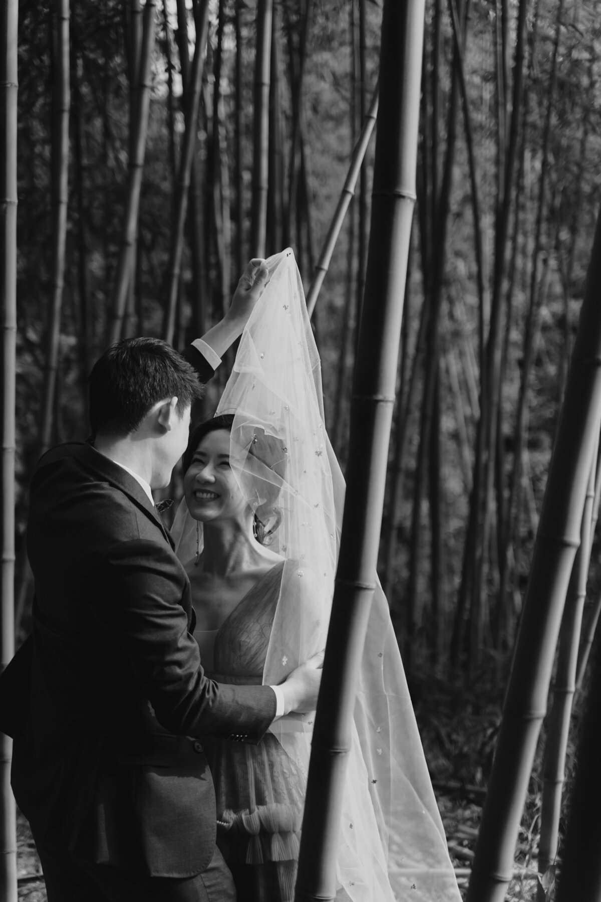 a groom lifts the bride's veil in Damyang Bamboo forest
