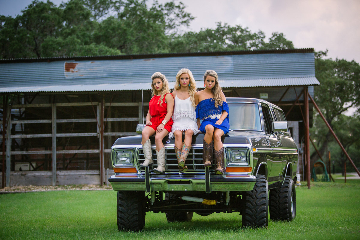high school senior session of three girls sitting on truck by San Antonio senior photographer