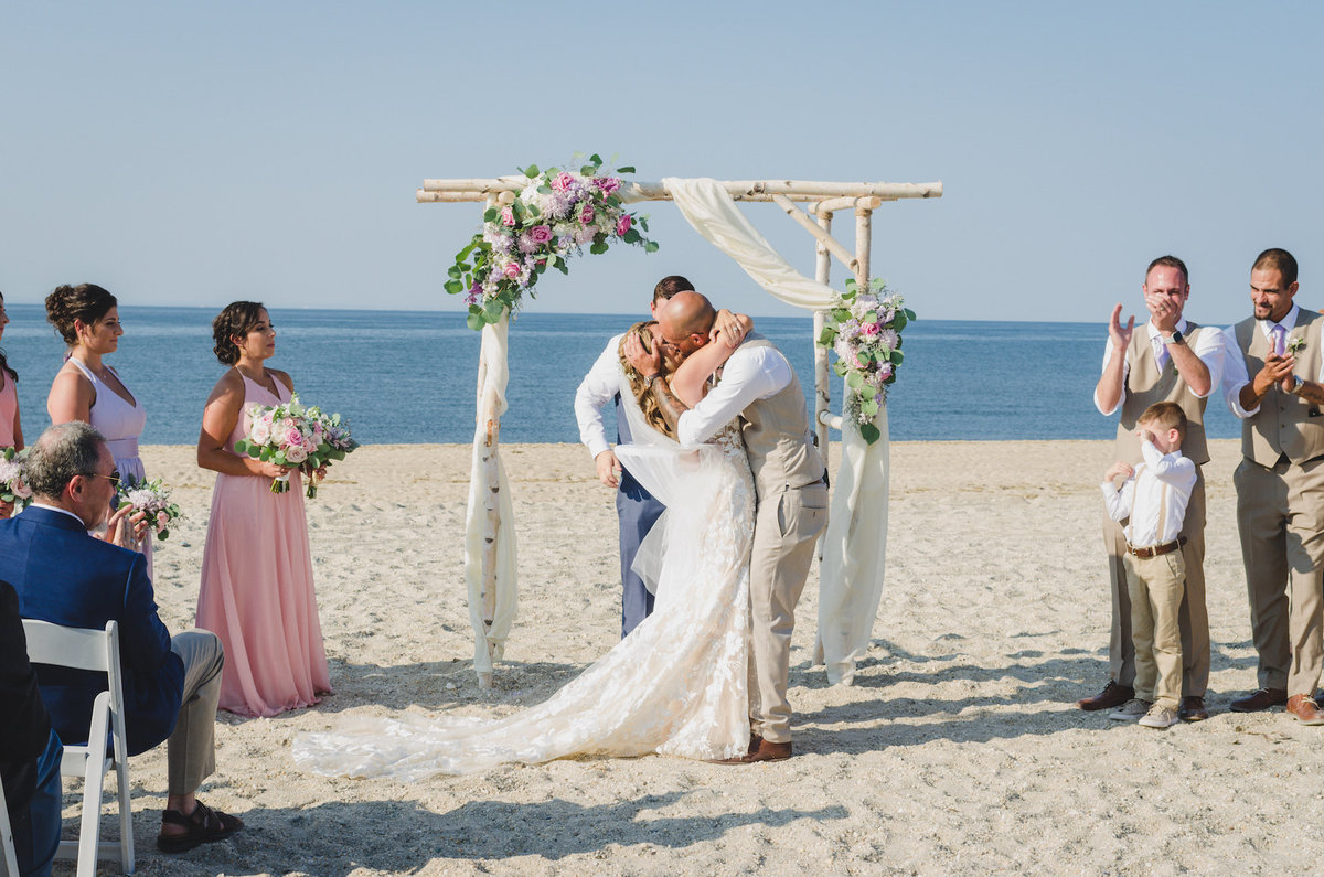 photo of bride and groom hugging after wedding ceremony on the beach at Pavilion at Sunken Meadow