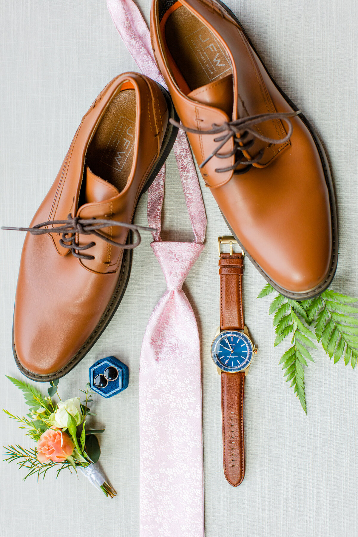detail photo of groom's tie, shoes watch and ring box