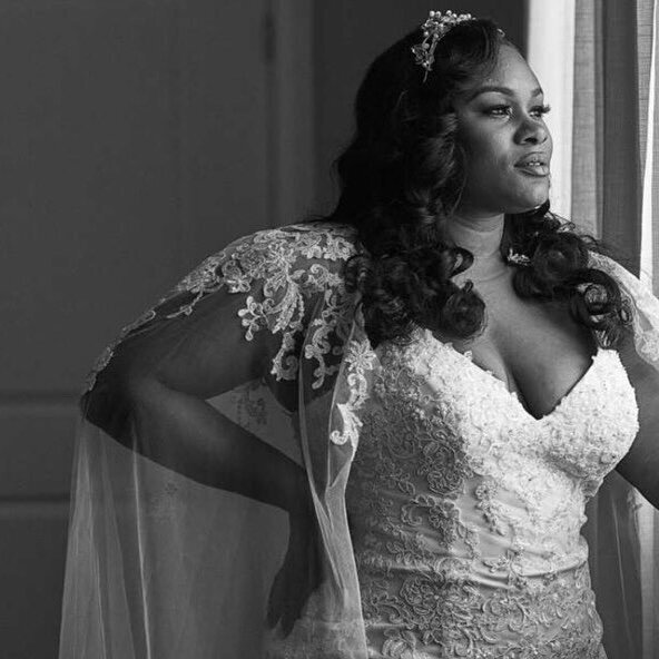 Portrait of a plus size bride wearing a wedding gown with lace details and a bolero.