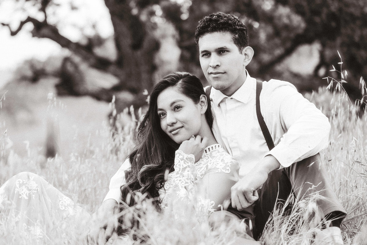 Engagement Photograph Of Woman Leaning On The man's Arms While Seated Black And White Los Angeles
