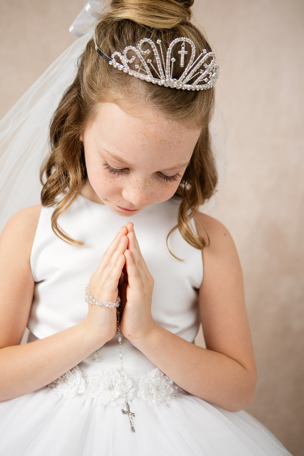 Professional little beauty portrait of girl in white dress and tiara