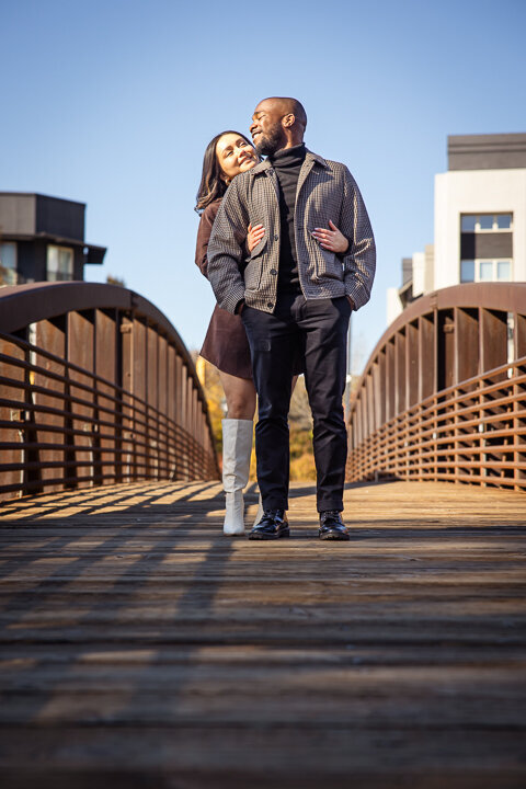 Playful engagement shoot with a couple laughing at the Millennium Gate museum