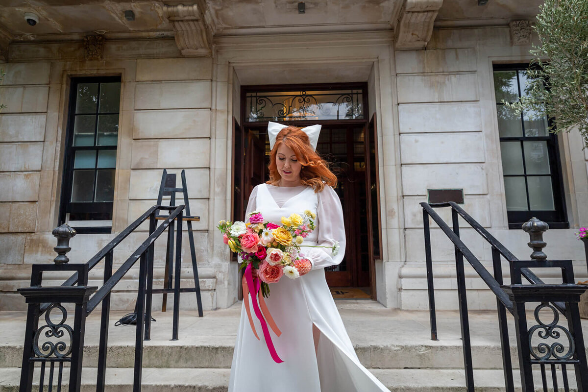 Bride looking at flowers outside Town Hall Hotel