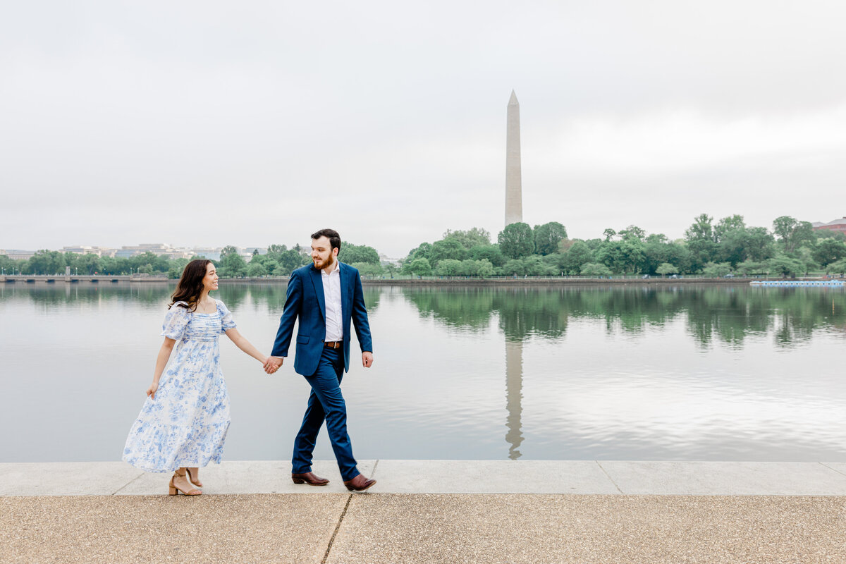 couple engagement walking near water washington monument jefferson memorial