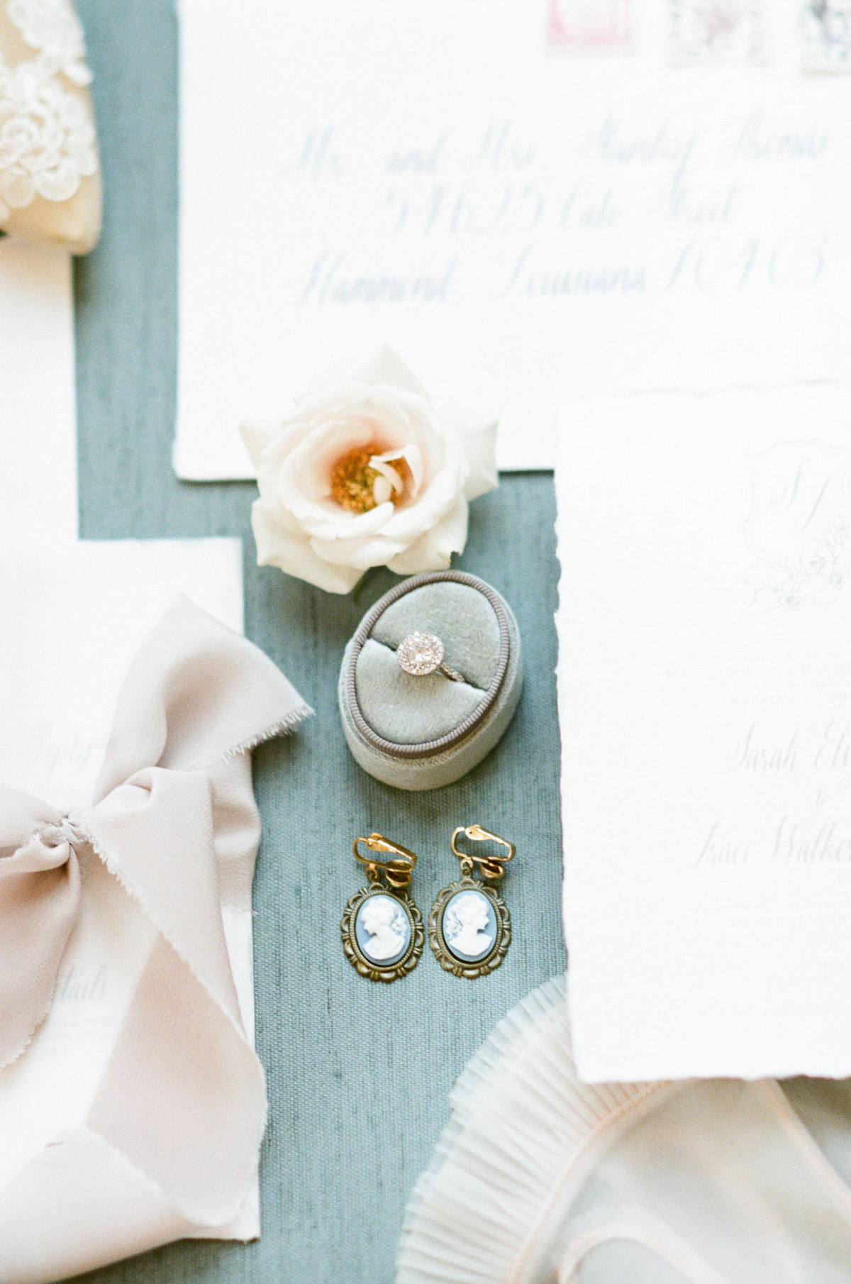 Flatlay of wedding stationery, earrings, and wedding details