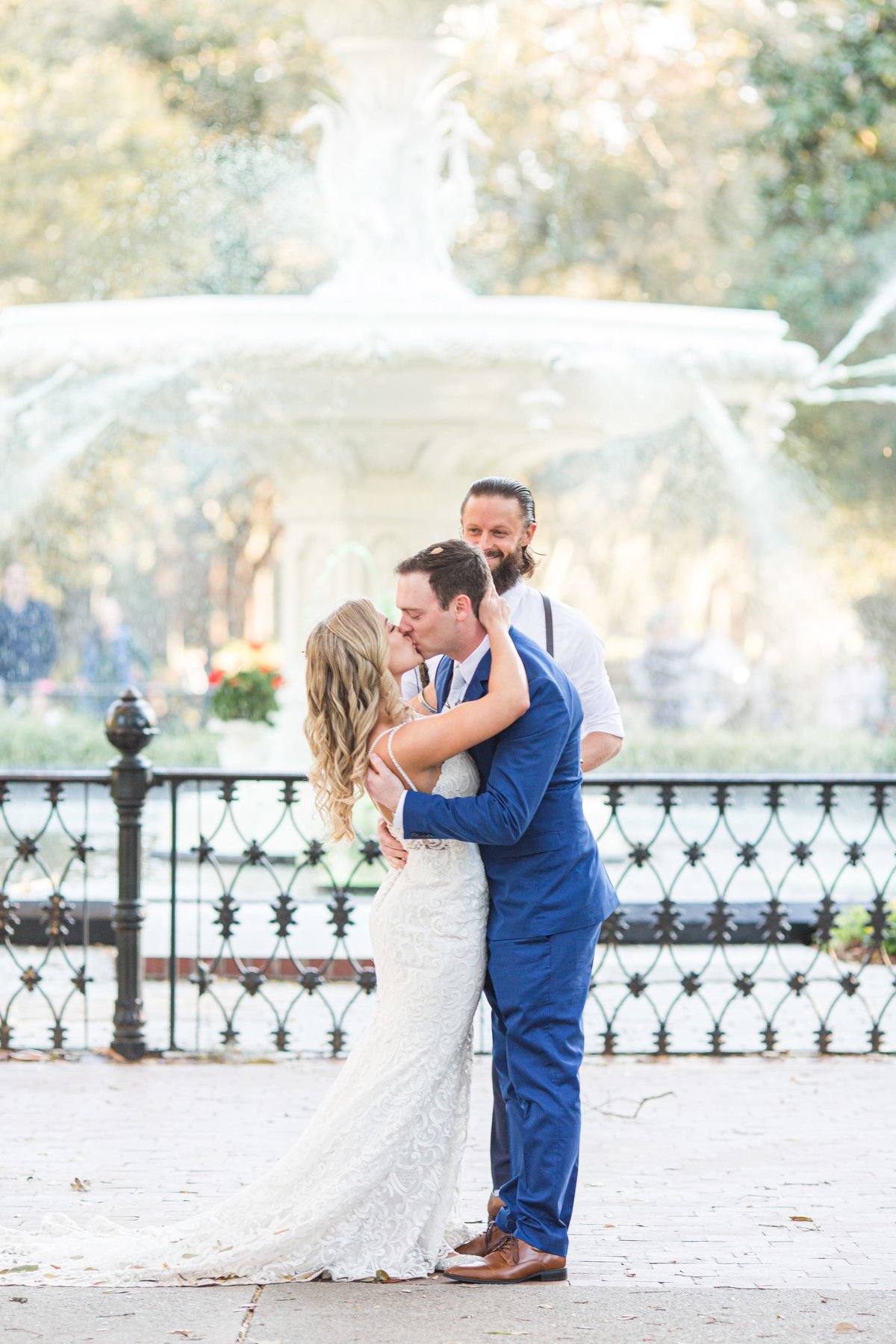 bride and groom first kiss in front of forsyth park fountain