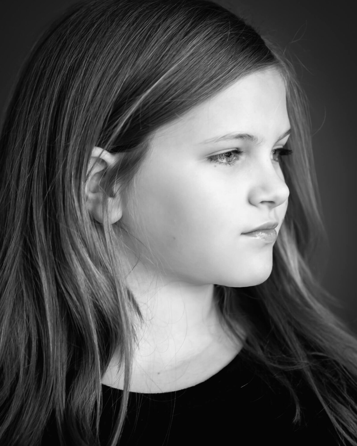 personality portrait in black and white of a 10 year old girl's profile with a serious face captured by Allison Amores Photography